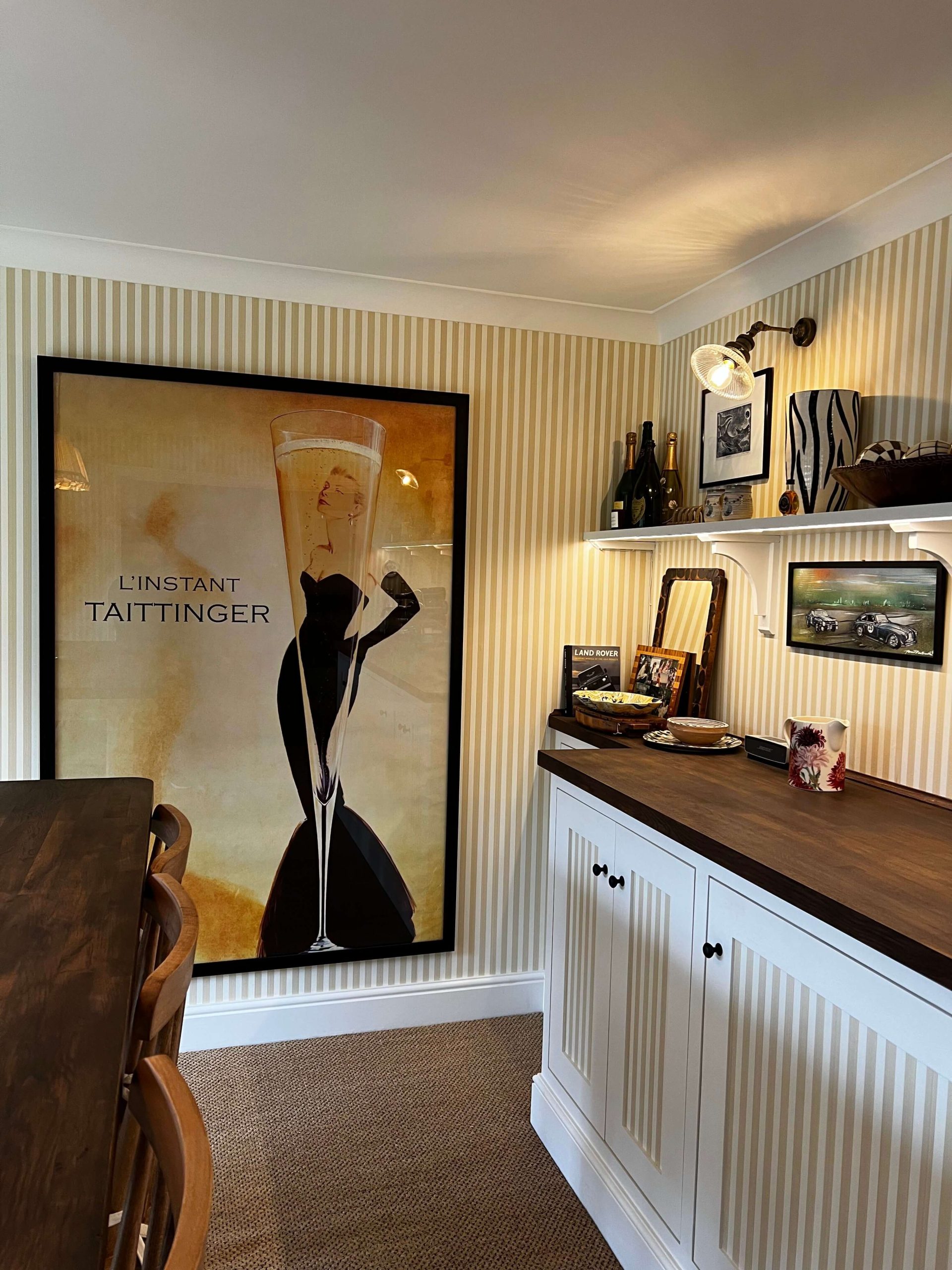 Home Painted sideboard with fluted doors and dark timber worktop in a striped dining room