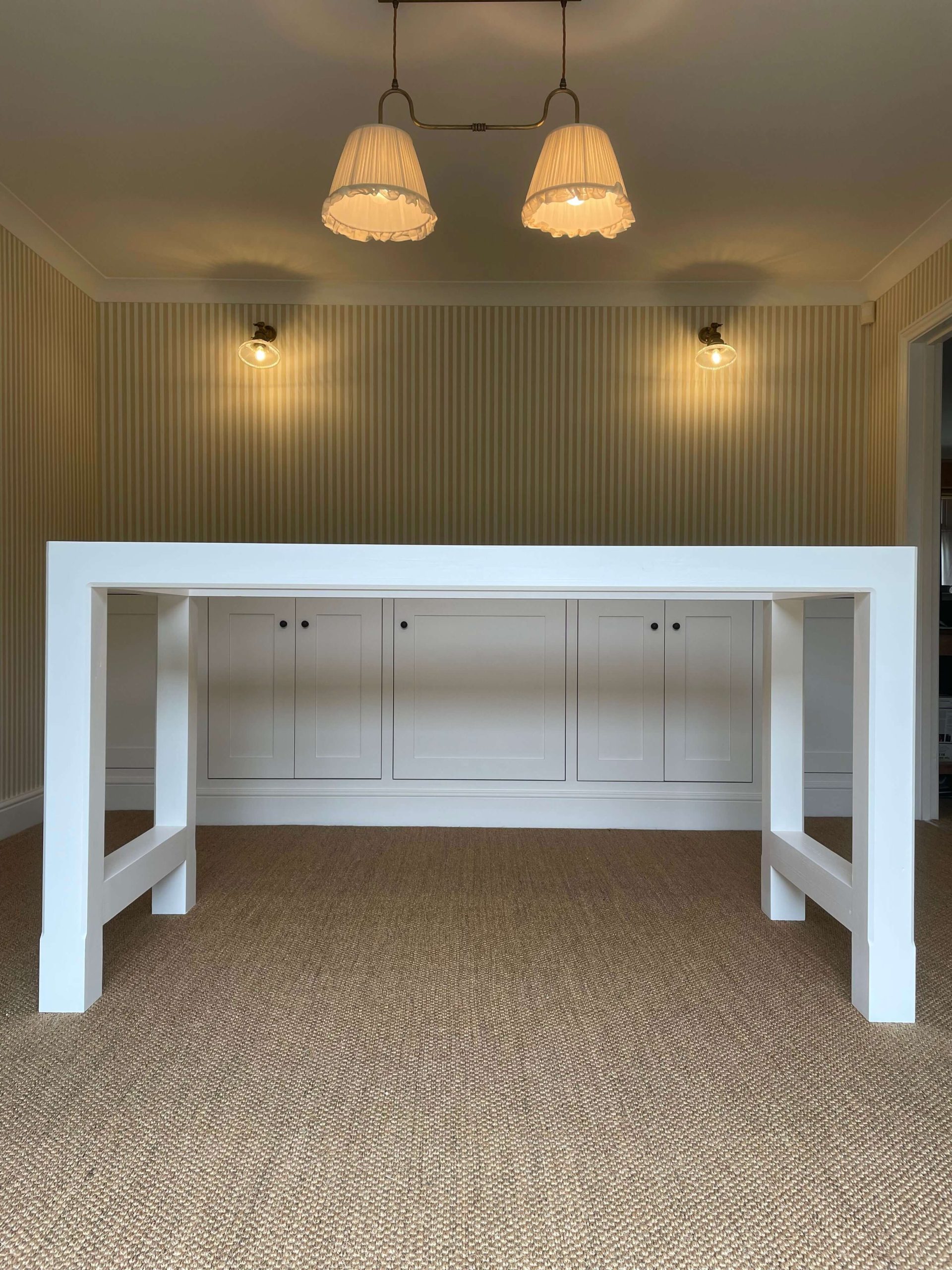 Home Painted breakfast bar with a built-in cupboard run behind, under twin pendant lights