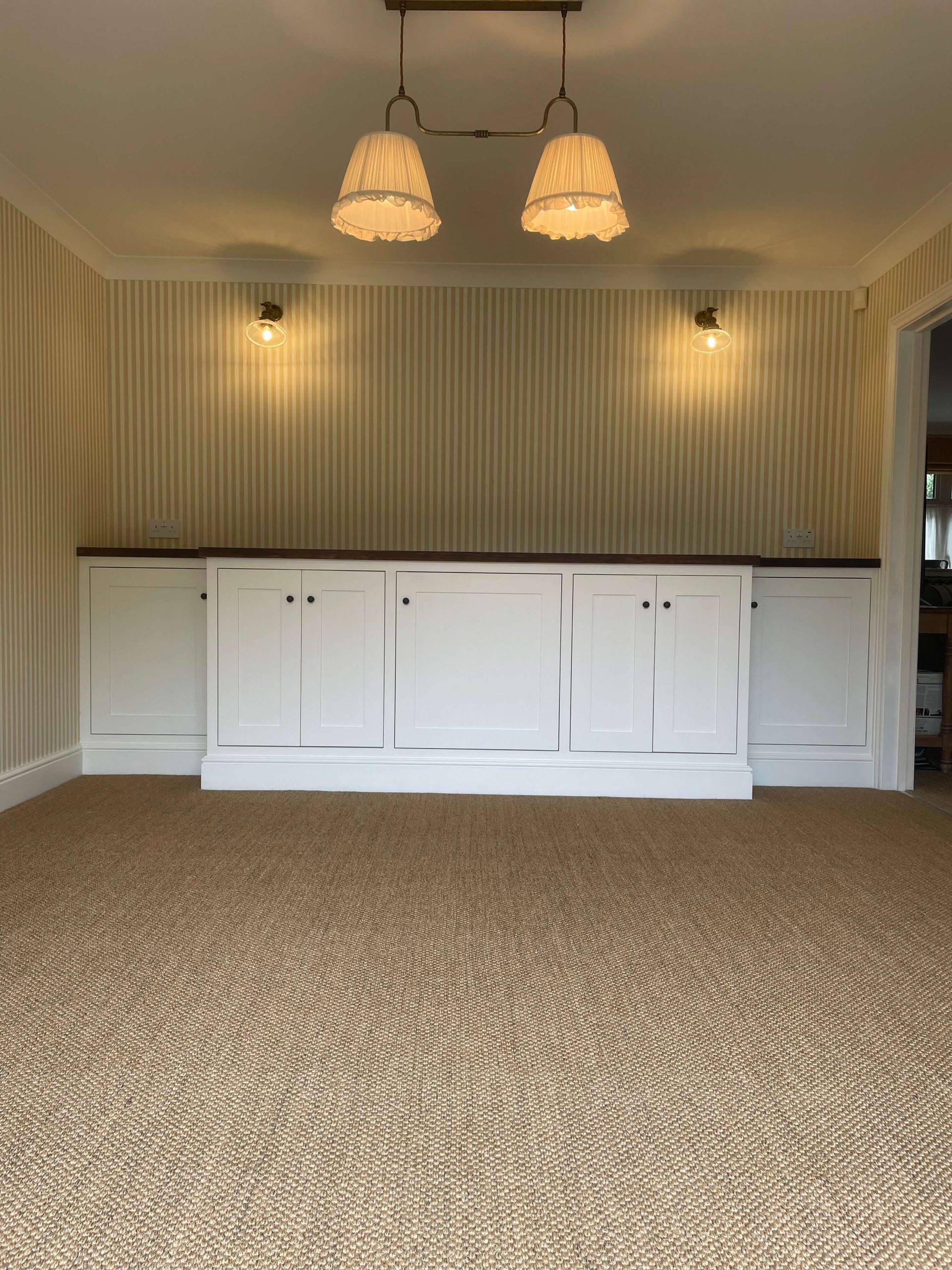 Services Built-in cupboards with painted shaker doors and a dark timber top against striped wallpaper