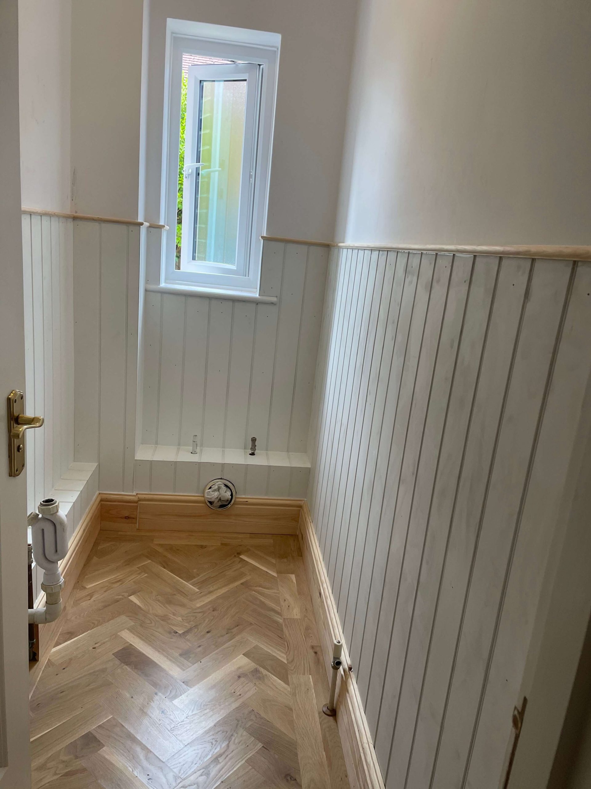 Home Cloakroom lined with white tongue-and-groove panelling and a herringbone oak floor