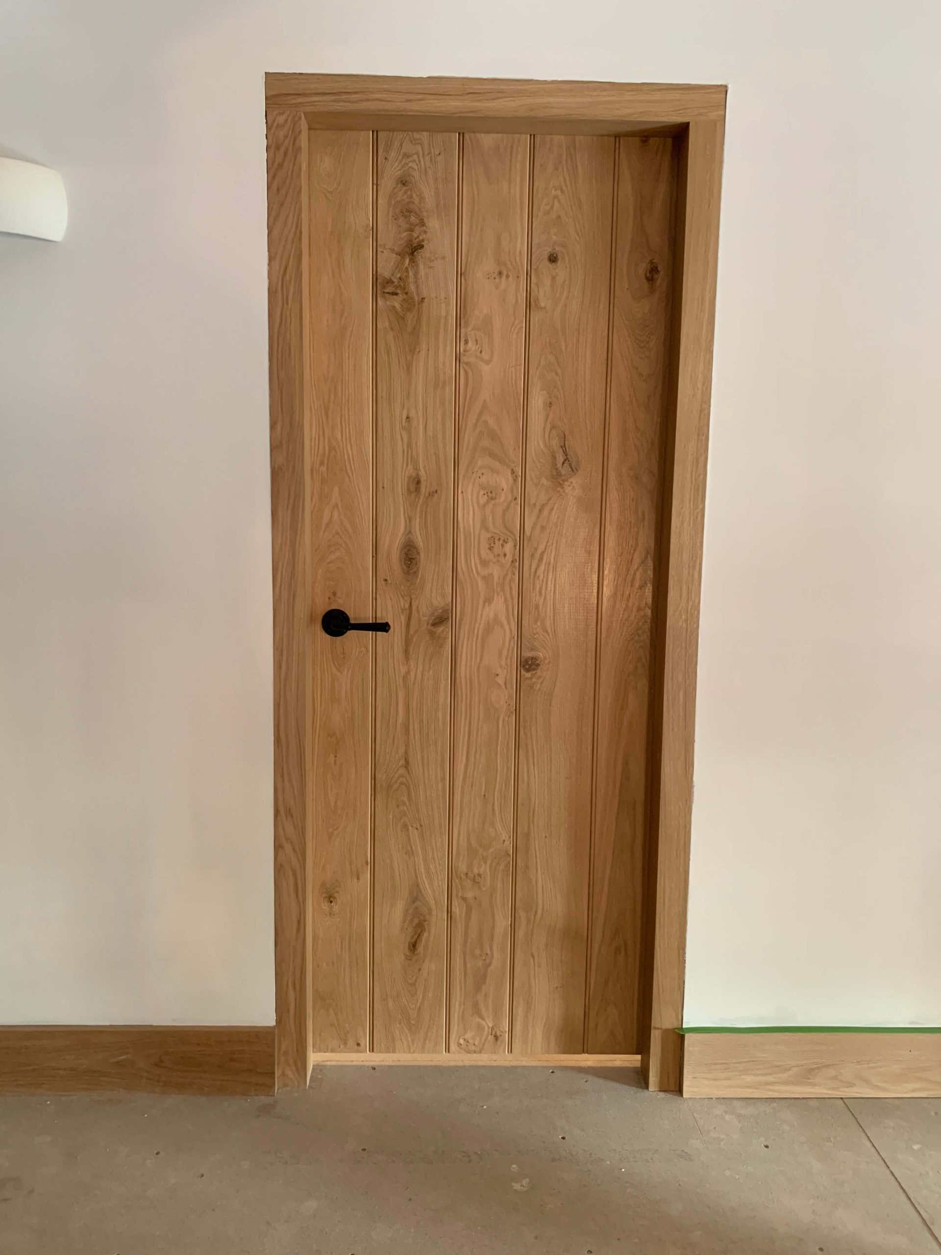 Cloakroom fitted with tongue-and-groove panelling, dado rail and herringbone oak flooring