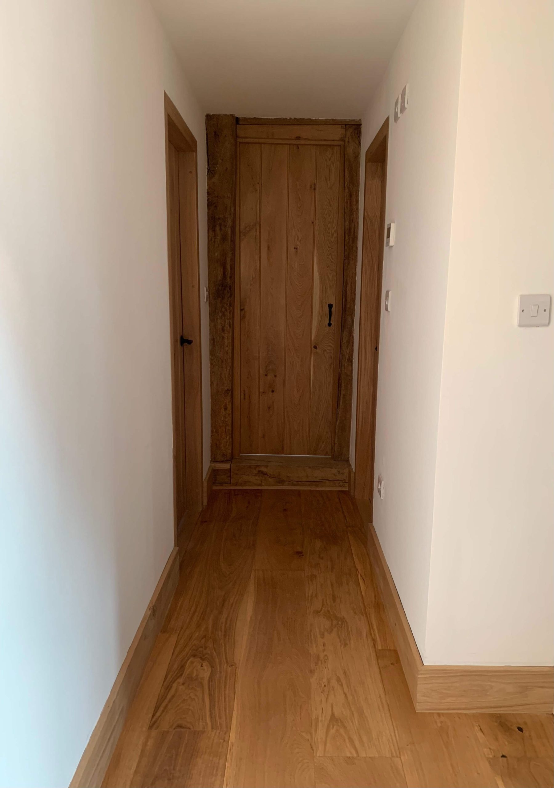 Home Solid oak ledged door with black ironmongery in a matching oak frame